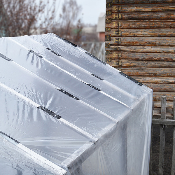 A greenhouse cover after being repaired using heavy-duty Greenhouse Material Repair Tape