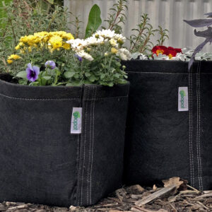 Flowers bloom from the GeoPot Round Bottom Fabric Pot container, perfect for showcasing ornamentals