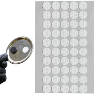 Cultivator holding up a gloved hand with jar lid with self-healing injection port stuck onto it in front of a sheet of the self-healing injection ports.