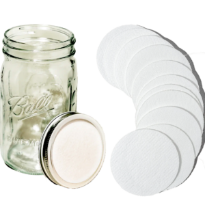 Jar lid filter discs next to a mason jar.