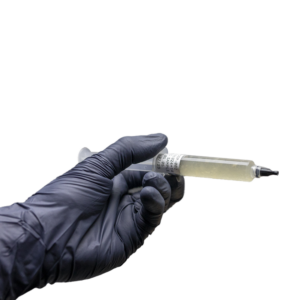 Person wearing black gloves holding a syringe on a transparent background